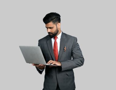 man in suit holding a laptop